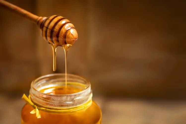 Decorative image of a jar of honey and a honey dipper